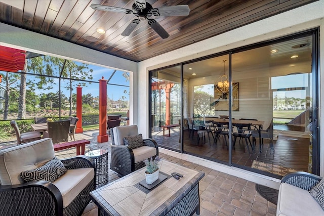 sunroom / solarium featuring wooden ceiling and a ceiling fan