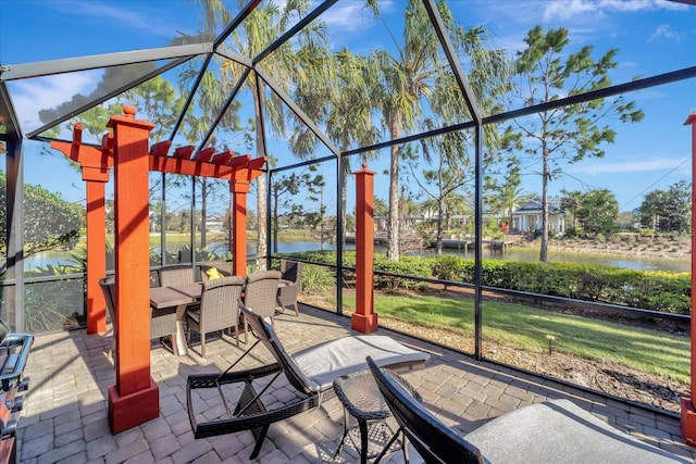 view of patio / terrace featuring a lanai and a water view