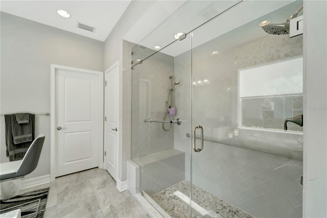 bathroom featuring a stall shower, baseboards, and visible vents