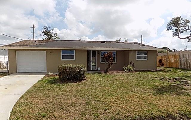 ranch-style house featuring a garage and a front yard