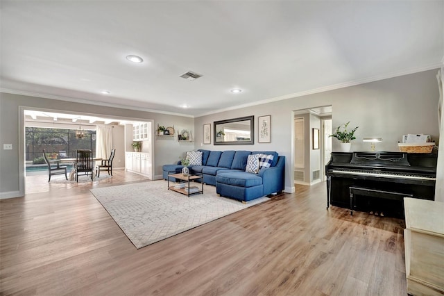 living room featuring visible vents, crown molding, and wood finished floors