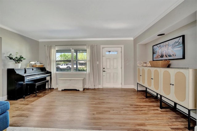 foyer featuring ornamental molding, wood finished floors, and baseboards