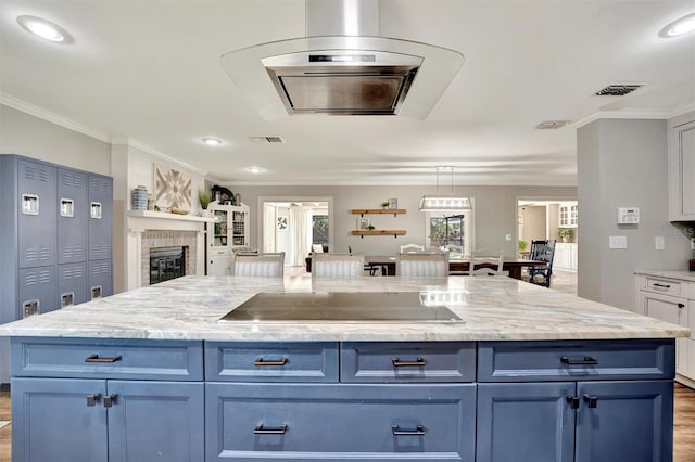 kitchen with blue cabinets, visible vents, black electric stovetop, and crown molding