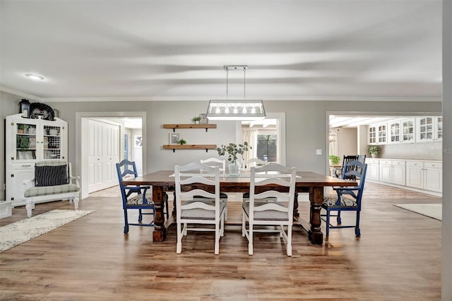 dining room with crown molding and light wood finished floors