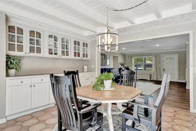 dining room featuring beam ceiling, baseboards, and an inviting chandelier