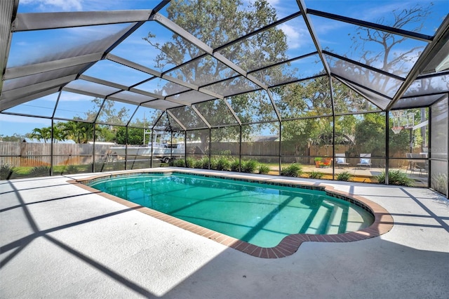 view of pool with glass enclosure, a patio area, fence, and a fenced in pool