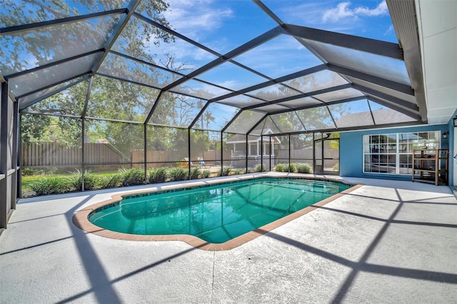 view of swimming pool featuring a lanai, a patio area, fence, and a fenced in pool