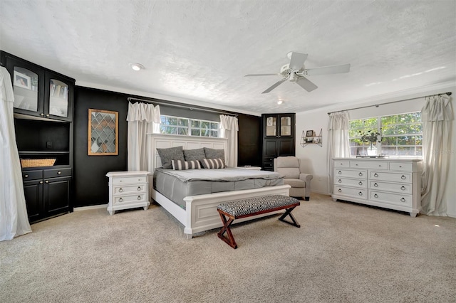 bedroom featuring carpet, baseboards, ceiling fan, and a textured ceiling