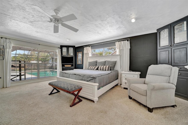 bedroom featuring a textured ceiling, ceiling fan, access to outside, and multiple windows