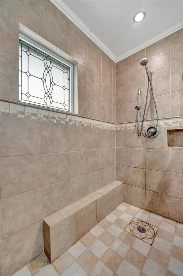 bathroom featuring a tile shower and crown molding