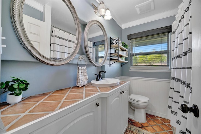 full bathroom with toilet, vanity, visible vents, wainscoting, and crown molding