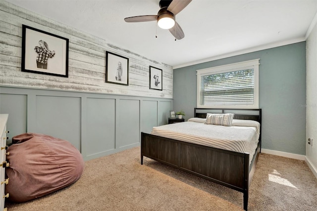 carpeted bedroom featuring ceiling fan and a decorative wall