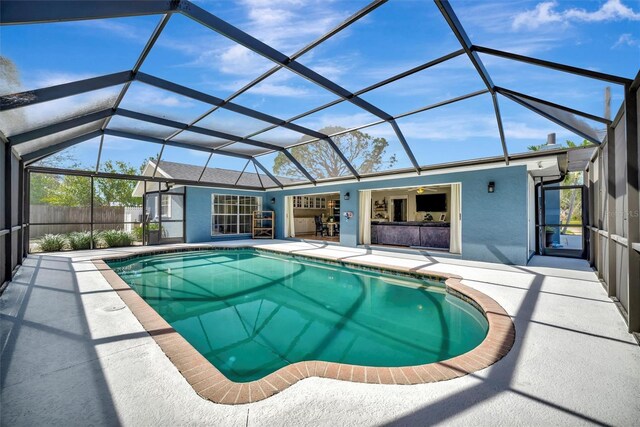 view of pool with a patio, glass enclosure, fence, and a fenced in pool