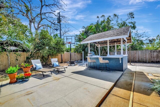 view of patio featuring outdoor dry bar and a fenced backyard