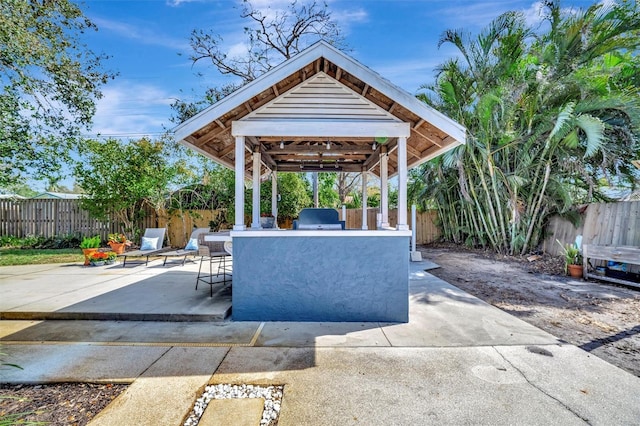 view of patio with a gazebo, a fenced backyard, outdoor dry bar, and area for grilling