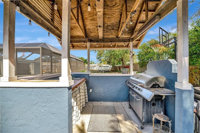 view of patio / terrace featuring glass enclosure and fence