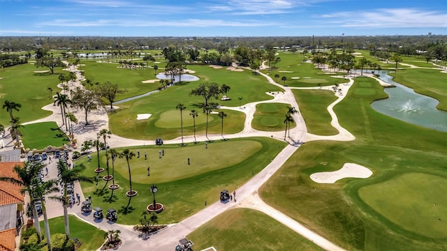 birds eye view of property with golf course view and a water view