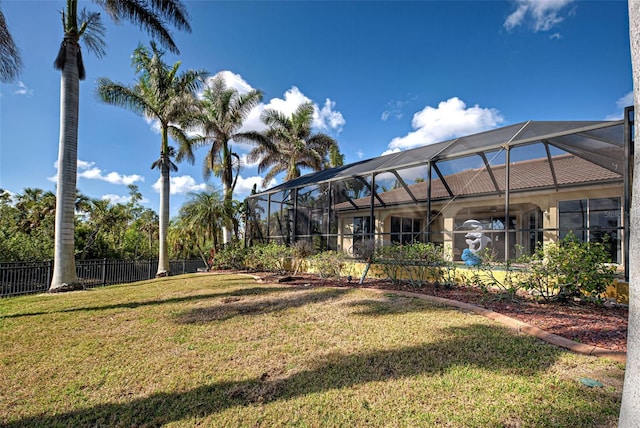 view of yard with a lanai and fence