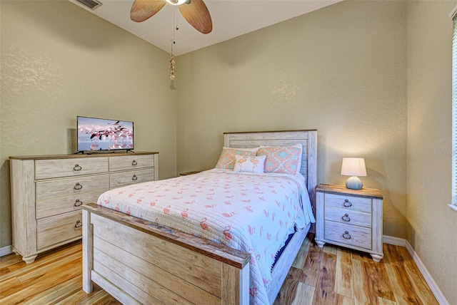 bedroom with light wood-type flooring, ceiling fan, and baseboards