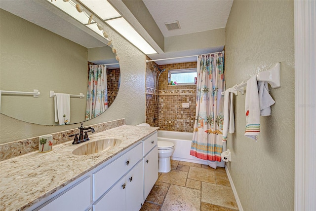 bathroom featuring stone tile floors, shower / bath combination with curtain, toilet, vanity, and a textured ceiling