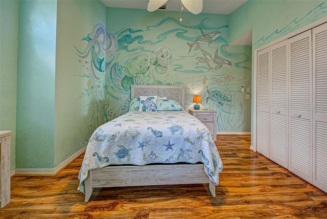 bedroom featuring a closet, baseboards, and wood finished floors