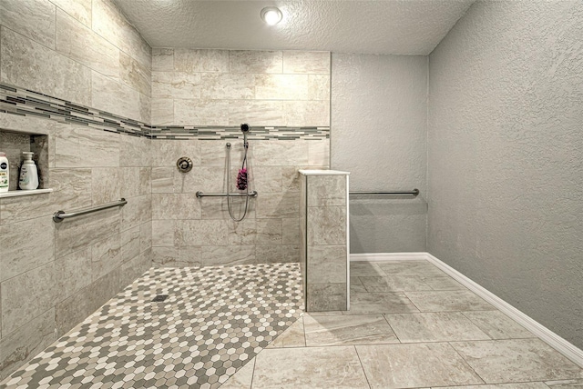 full bathroom featuring a textured wall, walk in shower, and baseboards