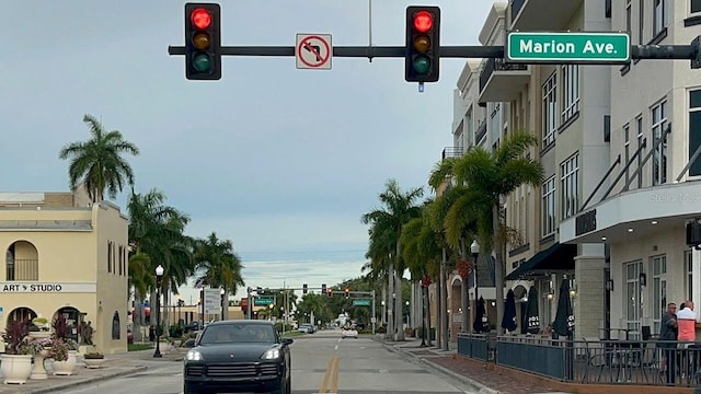 view of street with traffic lights, traffic signs, and sidewalks