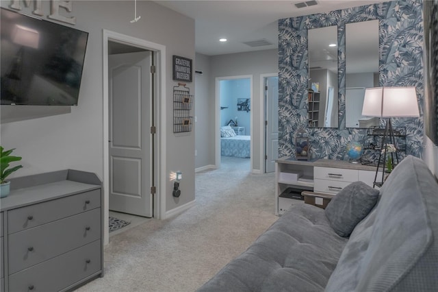 living area featuring baseboards, visible vents, and light colored carpet