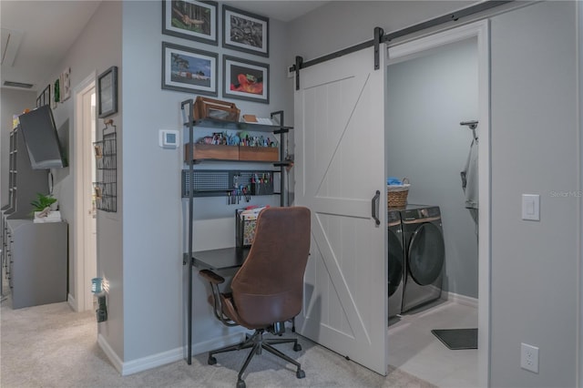 office area with separate washer and dryer, a barn door, carpet flooring, and baseboards