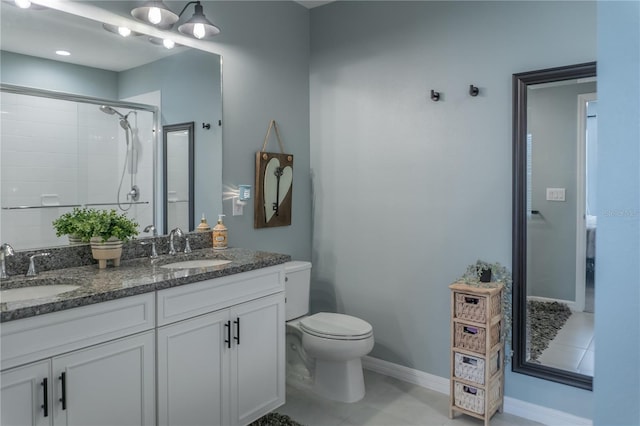 bathroom featuring a stall shower, a sink, toilet, and double vanity