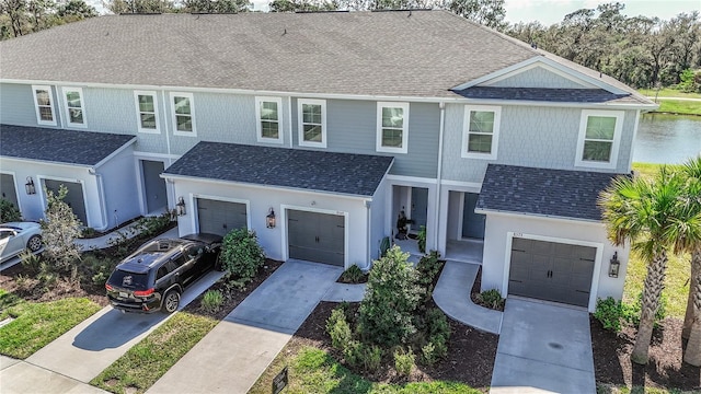 view of front facade featuring a garage, concrete driveway, and roof with shingles