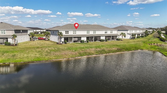 rear view of property featuring a residential view, a water view, and a yard