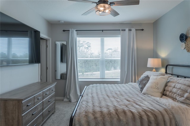 bedroom featuring a ceiling fan, light carpet, and baseboards