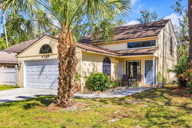 view of front facade with an attached garage, fence, concrete driveway, and a front yard