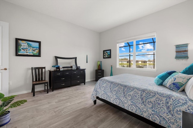 bedroom with light wood-type flooring and baseboards