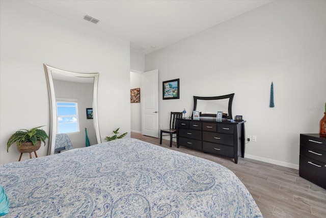 bedroom featuring baseboards, visible vents, and light wood-style floors