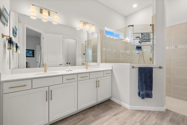 full bathroom featuring double vanity, wood tiled floor, a walk in shower, and a sink