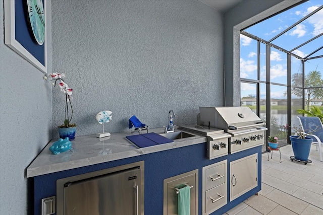 view of patio / terrace featuring an outdoor kitchen, glass enclosure, a water view, a grill, and a sink