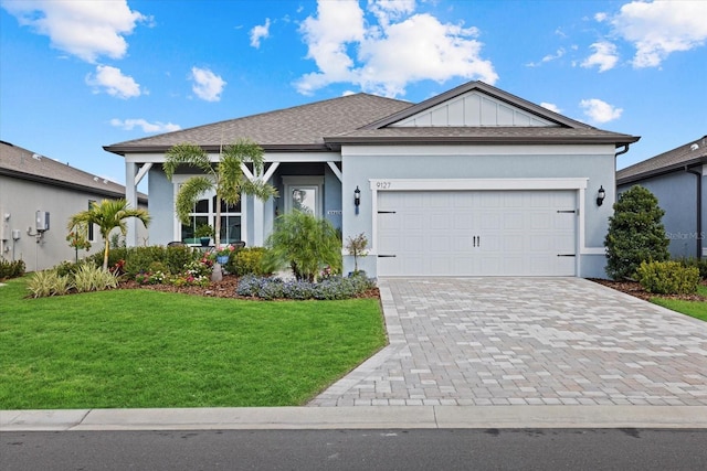 ranch-style house with board and batten siding, decorative driveway, an attached garage, and a front lawn