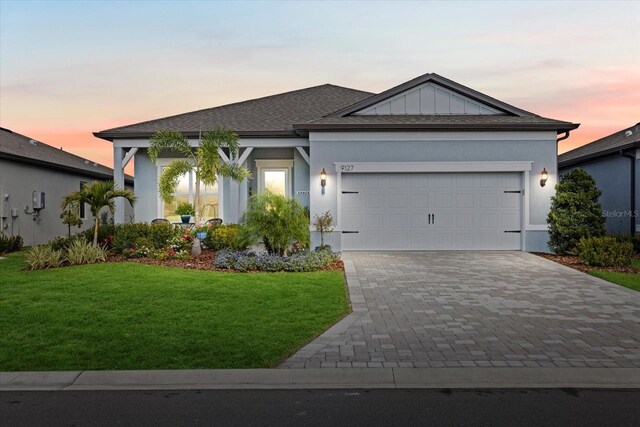9127 Barrier Coast Trl, Parrish, FL 34219 - view of front of property with driveway, a garage, a lawn, and stucco siding