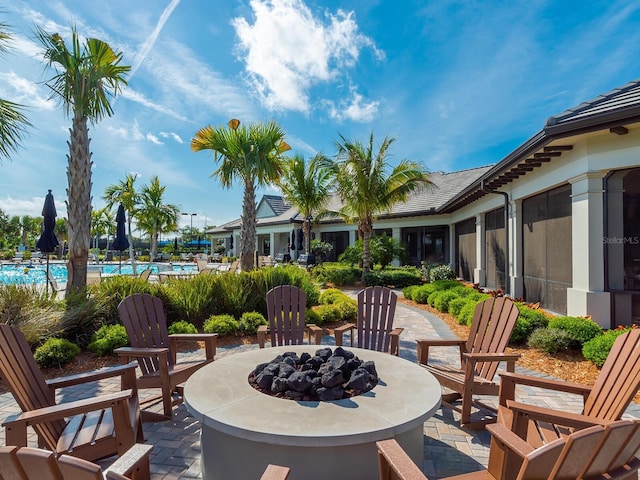 view of patio with an outdoor fire pit and a community pool