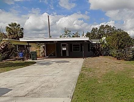 ranch-style home with a front lawn and a carport