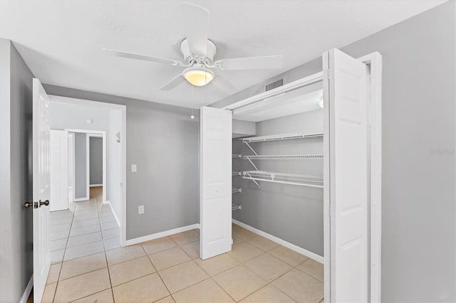 interior space featuring a closet, visible vents, light tile patterned flooring, ceiling fan, and baseboards