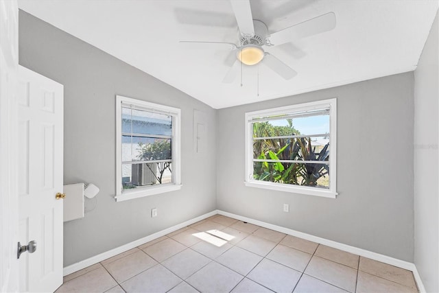 unfurnished room with light tile patterned floors, ceiling fan, vaulted ceiling, and baseboards