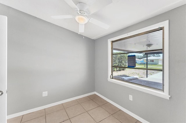 spare room featuring baseboards, a ceiling fan, and light tile patterned flooring