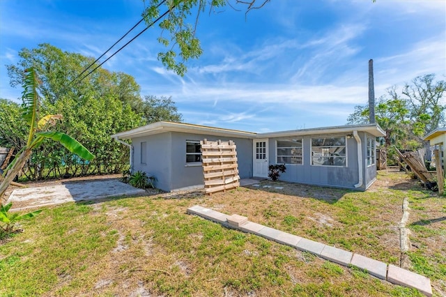 view of front of home with stucco siding and a front yard