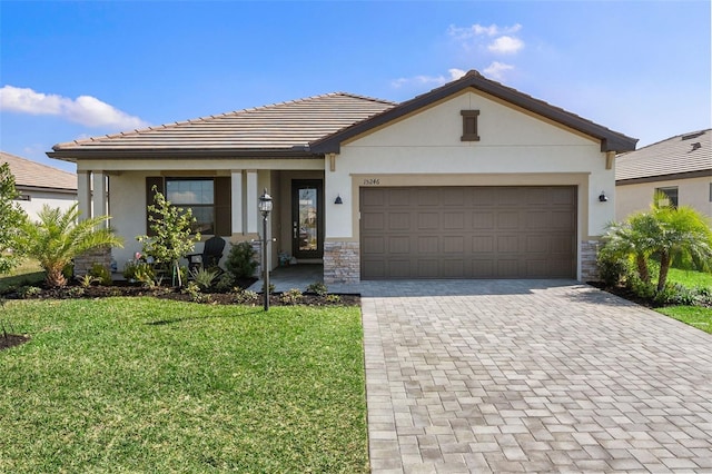 view of front of home featuring stone siding, stucco siding, decorative driveway, and a front yard