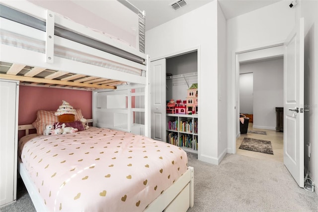 carpeted bedroom with a closet, visible vents, and baseboards