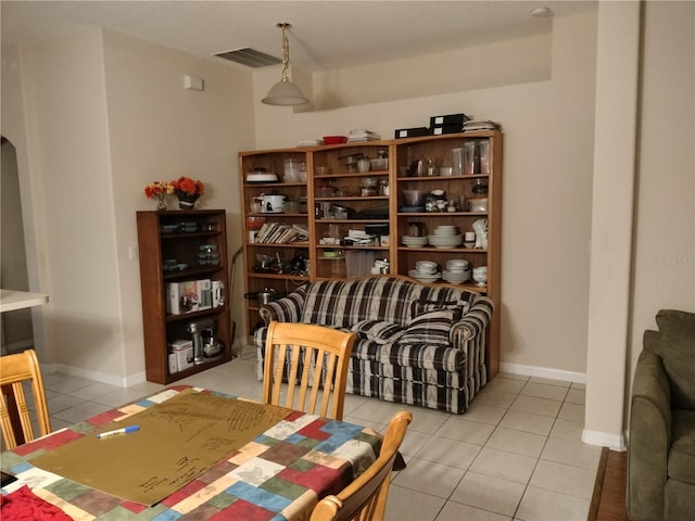 sitting room with light tile patterned floors, baseboards, visible vents, and arched walkways