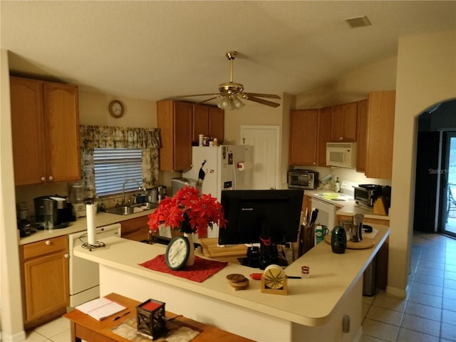 kitchen featuring light tile patterned floors, white microwave, a sink, visible vents, and light countertops